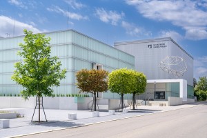 Außenansicht des Museums mit Laubbäumen vor blauem Himmel